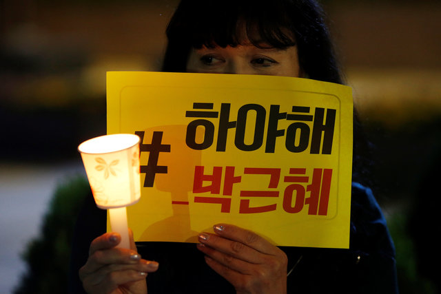 A woman attends a protest denouncing President Park Geun-hye over a recent influence-peddling scandal in central Seoul, South Korea, October 27, 2016. The banner reads "Call for Park Geun-hye to step down". (Photo: Reuters)