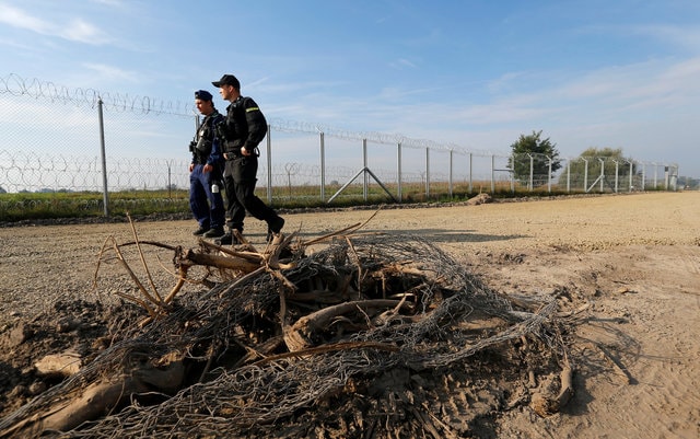Hungarian and Polish policeman patrol at the Hungary and Serbia border fence near the village of Asotthalom, Hungary. (Photo: Reuters)