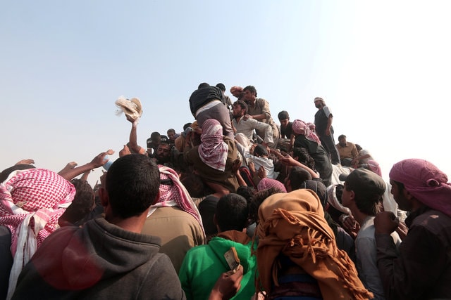 Iraqi refugees that fled violence in Mosul and internally displaced Syrians who fled Islamic State controlled areas in Deir al-Zor, buy food and water near the Iraqi border, in Hasaka Governorate October 23, 2016. (Photo: Reuters)
