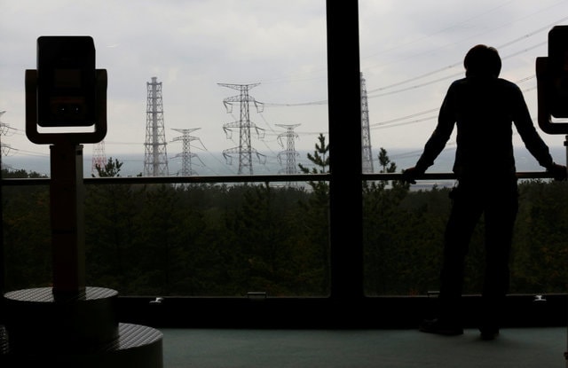 A visitor is silhouetted next to a pair of binoculars as he looks at Tokyo Electric Power Co.'s (TEPCO) Kashiwazaki Kariwa nuclear power plant, November 12, 2012. (Photo: Reuters)