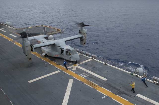 A landing signalman directs an Osprey aircraft to land on flight deck of the amphibious assault ship USS Bonhomme Richard (LHD 6), flagship of the Bonhomme Richard Expeditionary Strike Group, operating in the South China Sea on October 6, 2016. (Photo: US Navy/Handout via Reuters)