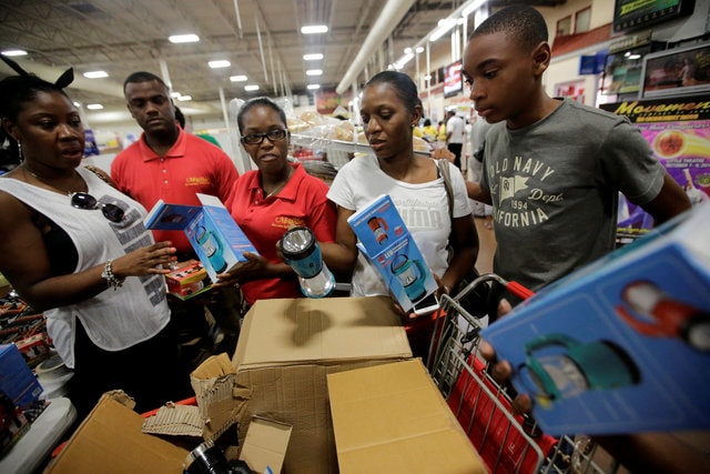 A saleswoman shows lamps to a customers while other people flock to the supermarket to take care of last minute shopping as Hurricane Matthew approaches in Kingston, Jamaica October 1, 2016. (Photo: Reuters)