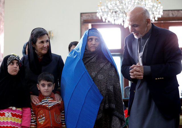 Afghanistan's President Ashraf Ghani speaks to Sharbat Gula, the green-eyed "Afghan Girl" whose 1985 photo in National Geographic became a symbol of her country's wars, after she arrived in Kabul, Afghanistan November 9, 2016. (Photo: Reuters)