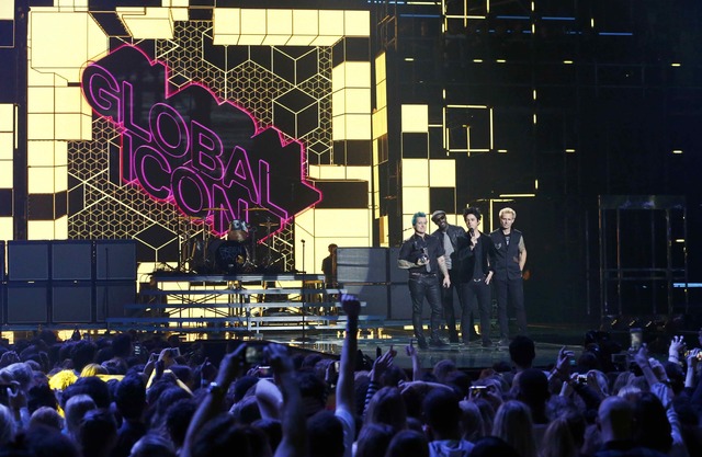 Green Day accept their Global Icon Award from actor Idris Elba (2nd L)  on stage at the 2016 MTV Europe Music Awards. (Photo: Reuters)