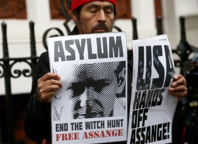A supporter of Julian Assange holds posters at Ecuador's embassy in London, Britain, November 14, 2016.  (Photo: Reuters)