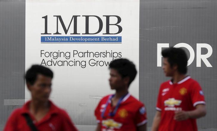 Men walk past a 1Malaysia Development Berhad (1MDB) billboard at the fund's flagship Tun Razak Exchange development in Kuala Lumpur March 1, 2015 (Photo: Reuters)