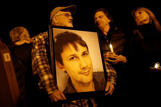 Brian Hough holds a photograph of his son Travis, who was among the deceased at the warehouse fire, during a vigil in Oakland, California, US, December 5, 2016. (Photo: Reuters)
