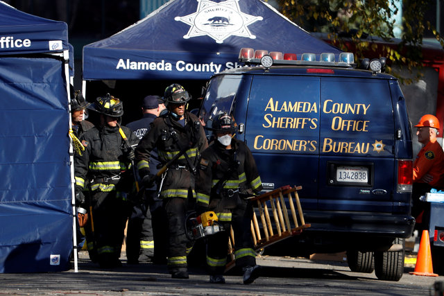 Firefighters carry equipment at the scene of a fire in the Fruitvale district of Oakland, California, US. (Photo: Reuters)