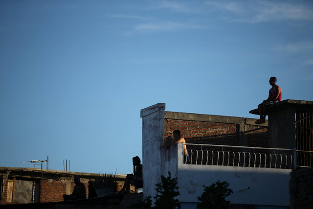People sit on roof tops while waiting for the ashes of Cuba's former President Fidel Castro to drive toward Santa Ifigenia cemetery in Santiago de Cuba, Cuba, December 4, 2016. (Photo: Reuters)