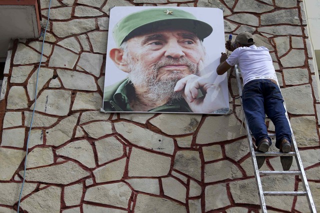 A man works on a portrait of Cuba's late President Fidel Castro as the town prepares for the arrival of the caravan carrying Castro's ashes in Las Tunas, Cuba, December 1, 2016.        (Photo: Reuters)
