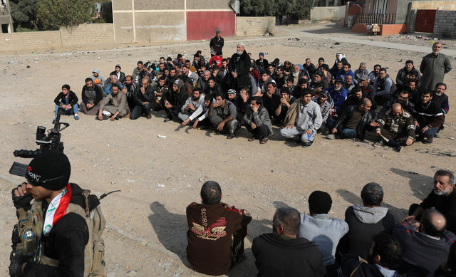 Men sit on the ground as an Iraqi Special forces intelligence team check their ID cards as they search for Islamic State fighters in Mosul, Iraq November 27, 2016. (Photo: Reuters)