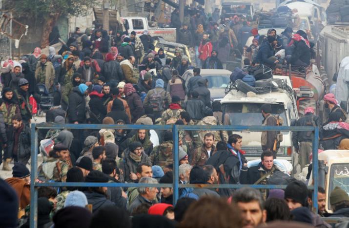 Rebel fighters and civilians gather as they wait to be evacuated from a rebel-held sector of eastern Aleppo, Syria. (Photo: Reuters)